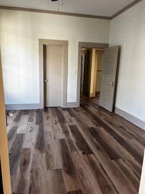 unfurnished bedroom featuring crown molding and dark hardwood / wood-style flooring