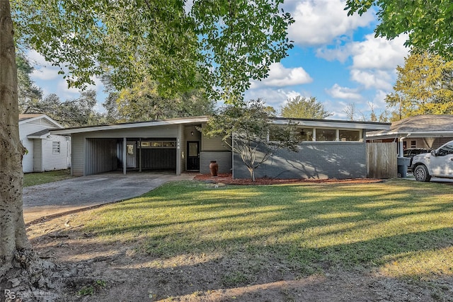 view of front of property featuring a carport, a front yard, and concrete driveway