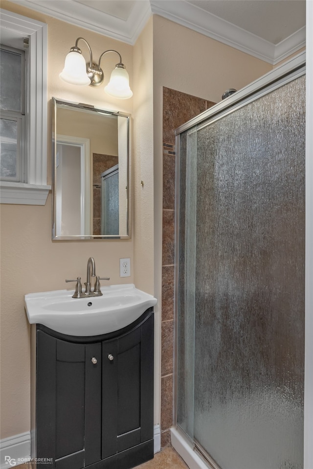 bathroom featuring vanity, a shower with shower door, and ornamental molding