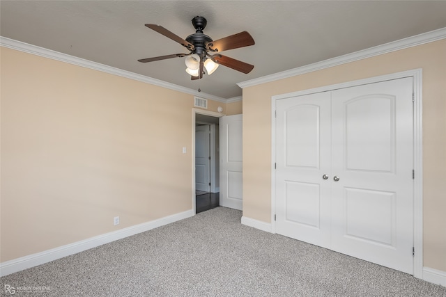 unfurnished bedroom featuring ornamental molding, carpet flooring, a closet, and ceiling fan