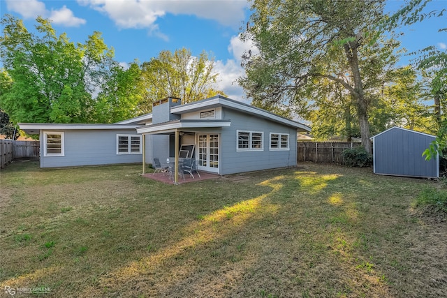 back of house with a patio area, a storage shed, and a lawn