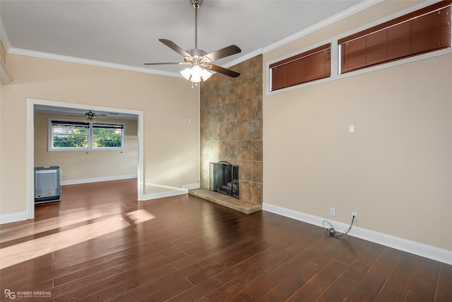 unfurnished living room with crown molding, ceiling fan, a tile fireplace, and dark hardwood / wood-style flooring