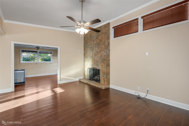 unfurnished living room with a tile fireplace, crown molding, a ceiling fan, baseboards, and wood finished floors