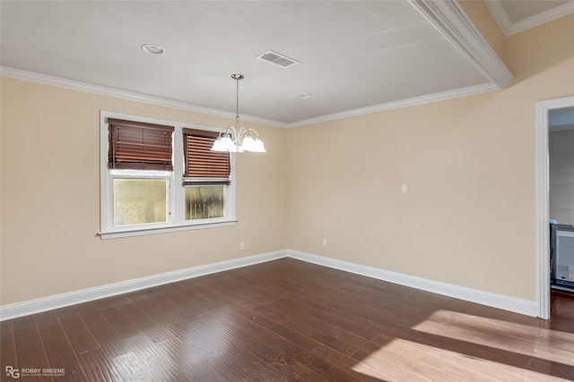 spare room with an inviting chandelier, ornamental molding, and dark wood-type flooring