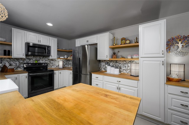 kitchen featuring appliances with stainless steel finishes, white cabinetry, tasteful backsplash, and butcher block countertops