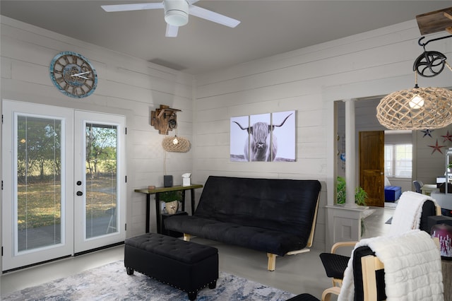 living room with french doors, concrete flooring, and ceiling fan