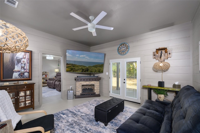 living room featuring a stone fireplace and ceiling fan