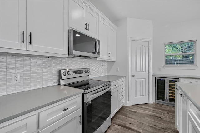 kitchen featuring wine cooler, hardwood / wood-style flooring, stainless steel appliances, decorative backsplash, and white cabinets