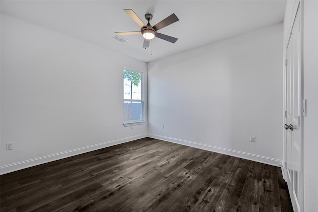 spare room featuring dark wood-type flooring and ceiling fan