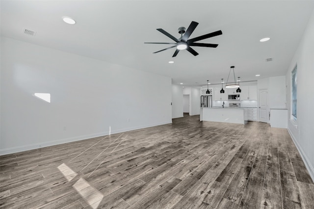 unfurnished living room with ceiling fan and light wood-type flooring