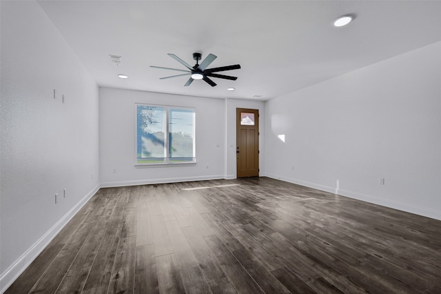 unfurnished living room featuring dark wood-type flooring and ceiling fan