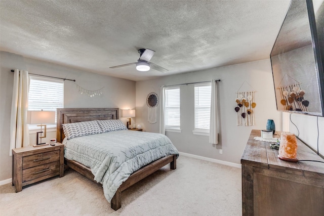 bedroom with ceiling fan, light colored carpet, and multiple windows