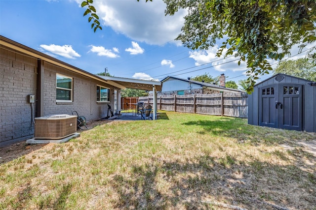 view of yard featuring a storage unit, a patio, and central AC unit