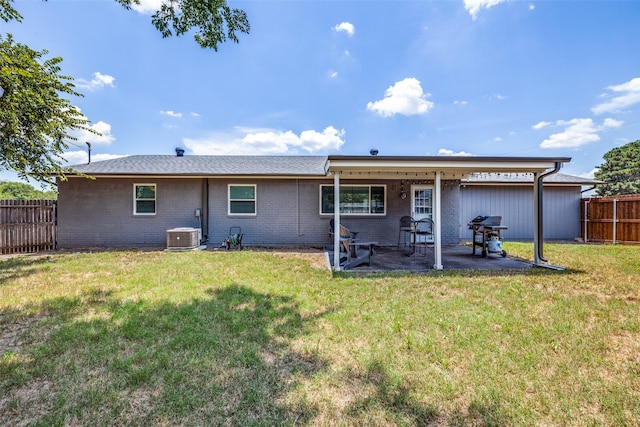 back of property with a yard, central AC unit, and a patio area