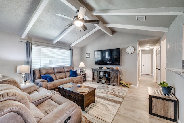 living room featuring vaulted ceiling with beams, ceiling fan, light hardwood / wood-style floors, and a textured ceiling