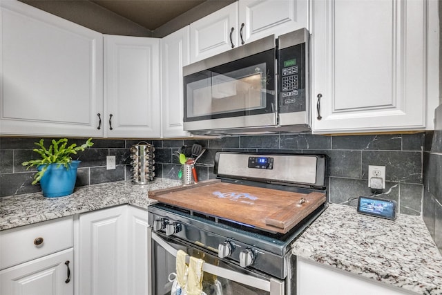 kitchen featuring tasteful backsplash, white cabinetry, and stainless steel appliances