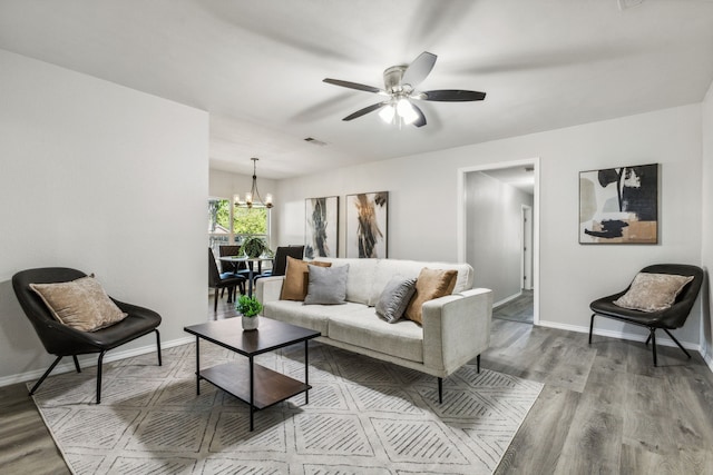 living room featuring ceiling fan with notable chandelier and light hardwood / wood-style floors