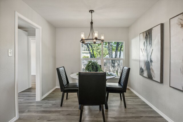 dining area featuring ceiling fan with notable chandelier and hardwood / wood-style floors