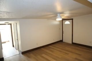 empty room with ceiling fan and light wood-type flooring