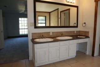 bathroom featuring tile patterned flooring, vanity, and tasteful backsplash