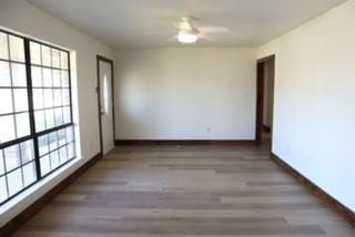 empty room featuring dark wood-type flooring and baseboards