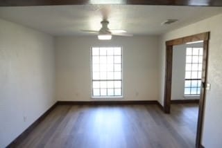 unfurnished room featuring ceiling fan and dark wood-type flooring