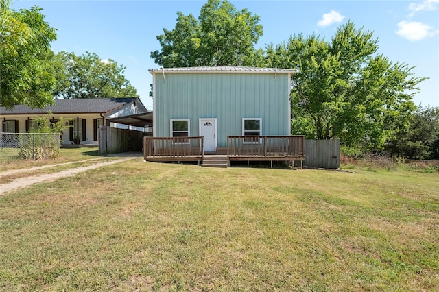 back of property with a wooden deck and a lawn