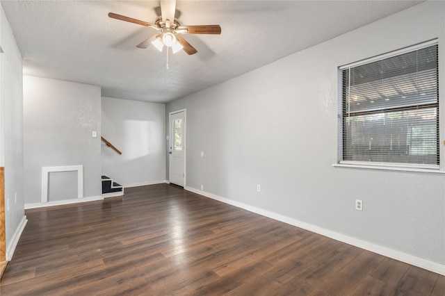 empty room with dark hardwood / wood-style floors, a textured ceiling, and ceiling fan