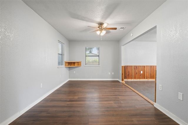 spare room featuring a textured ceiling, ceiling fan, and dark hardwood / wood-style flooring