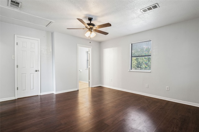 empty room with a textured ceiling, dark hardwood / wood-style floors, and ceiling fan