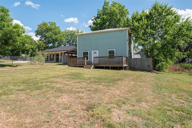 back of property with a yard and a wooden deck