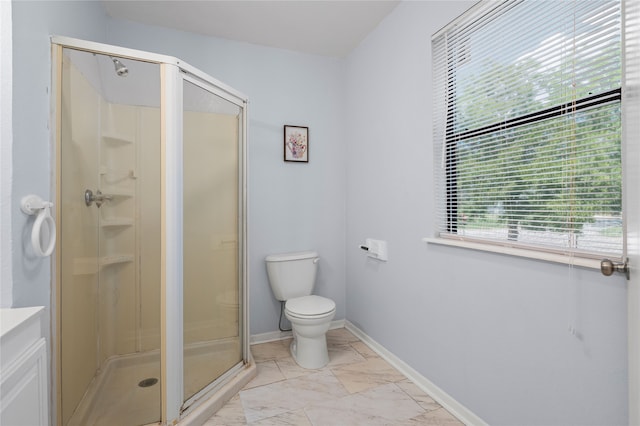 bathroom with toilet, vanity, and a shower with door