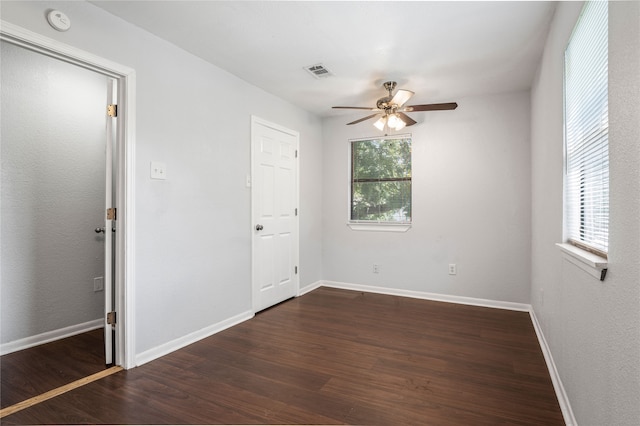 unfurnished room with ceiling fan and dark hardwood / wood-style flooring