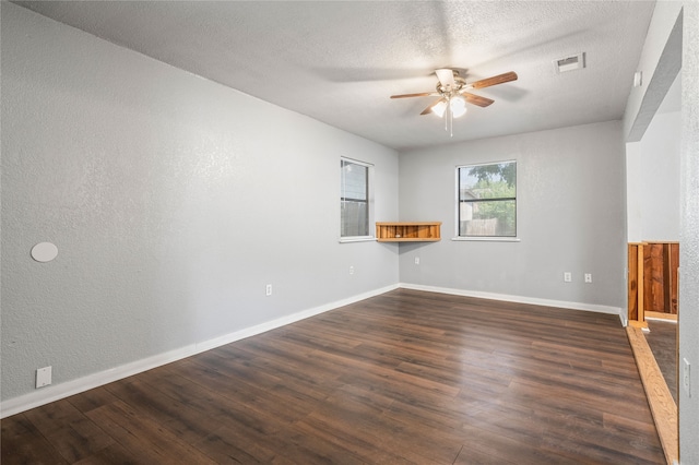 spare room featuring a textured ceiling, dark wood-type flooring, and ceiling fan