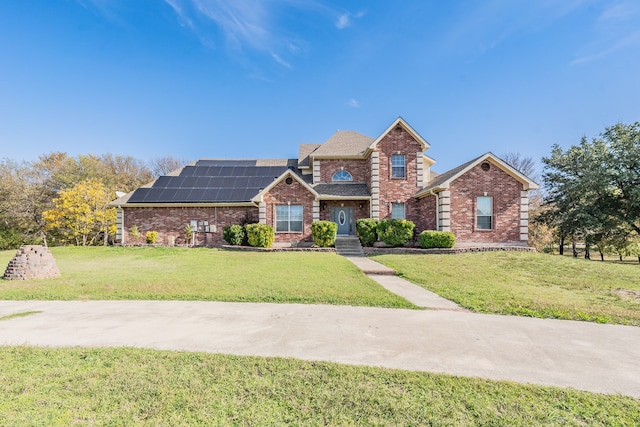 view of front of home with a front lawn and solar panels