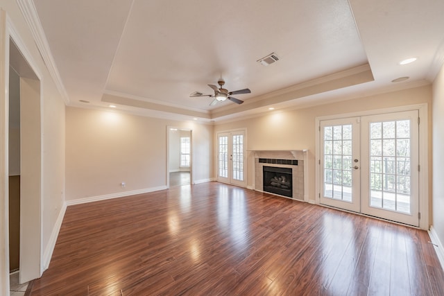 unfurnished living room featuring french doors, ornamental molding, a raised ceiling, and dark wood-type flooring