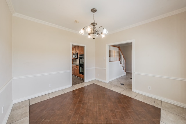 tiled spare room featuring ornamental molding and a notable chandelier