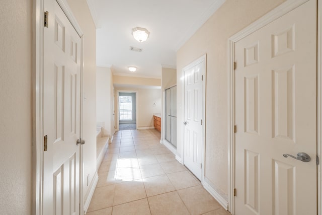 hallway featuring light tile patterned flooring and ornamental molding