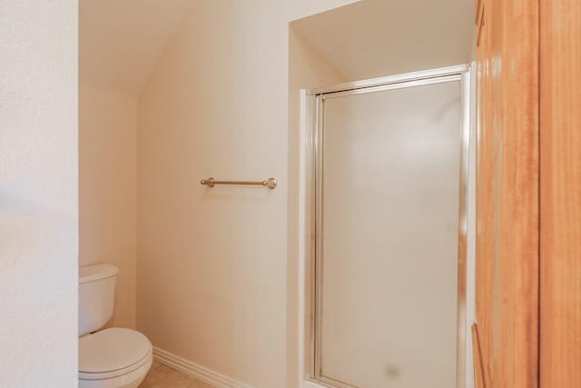 bathroom with tile patterned flooring, a shower with shower door, toilet, and vaulted ceiling