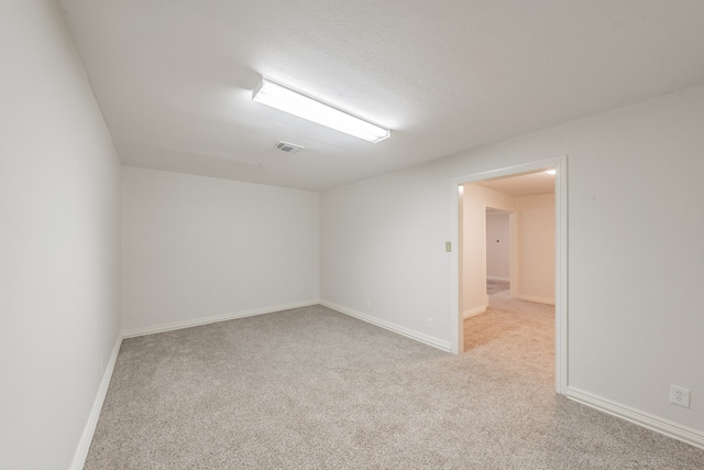 spare room featuring light carpet