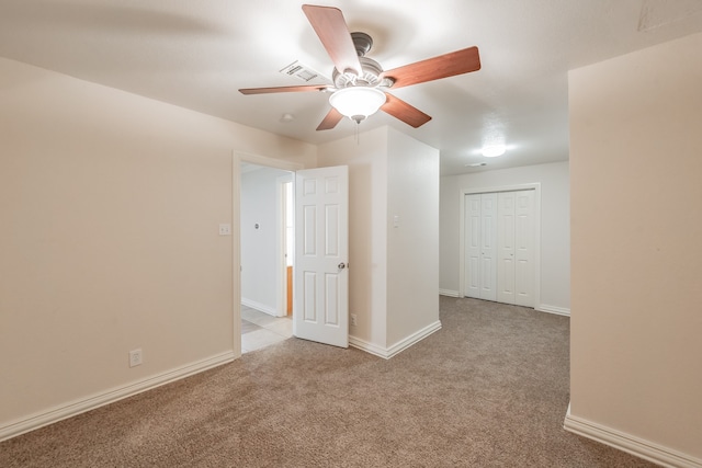 carpeted spare room with ceiling fan