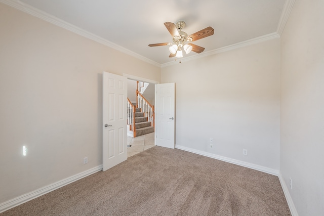 carpeted empty room featuring ceiling fan and crown molding