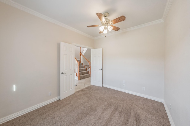 empty room with light carpet, crown molding, and ceiling fan