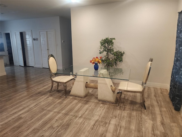 dining area featuring baseboards and wood finished floors