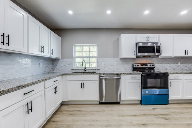 kitchen with appliances with stainless steel finishes, white cabinets, and sink