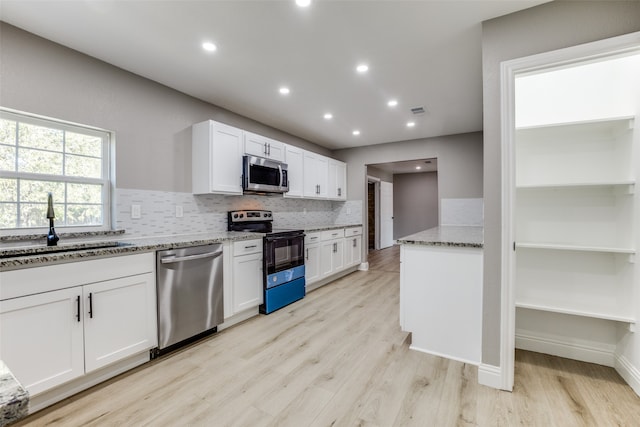 kitchen featuring white cabinetry, stone countertops, stainless steel appliances, and light wood-type flooring