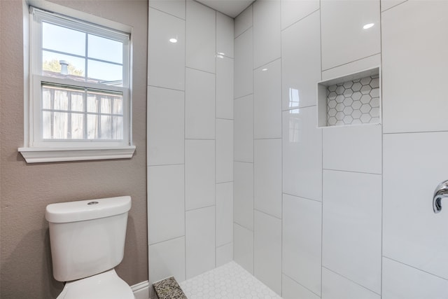 bathroom with toilet and tiled shower