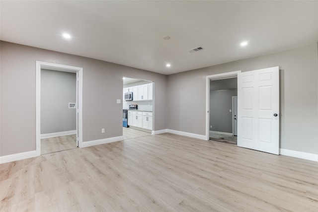 unfurnished bedroom featuring light hardwood / wood-style flooring and ensuite bathroom