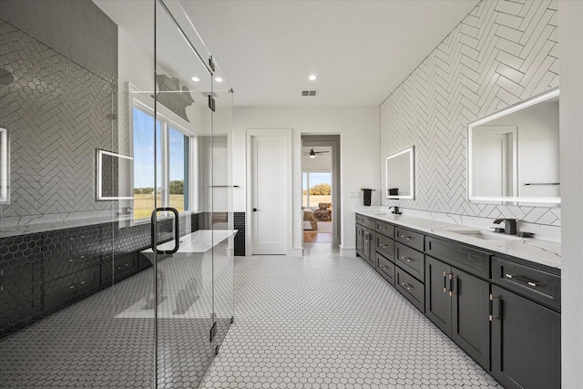 full bath with double vanity, decorative backsplash, a stall shower, and a sink