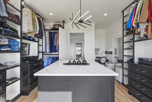 walk in closet with light hardwood / wood-style floors